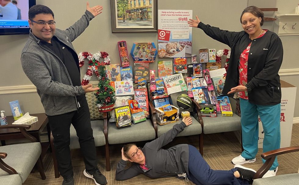 Dental team member in front of toys for donation