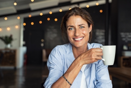 Woman smiling after dental implant tooth replacement