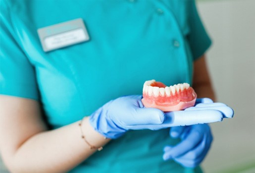 a closeup of a person holding dentures 