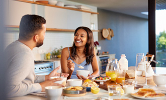 Couple smiling while enjoying meal together at home