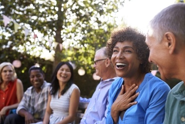 Woman smiling with friends after replacing missing teeth