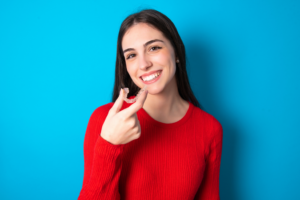a patient smiling and holding their Invisalign